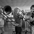 3 young children playing the trombone
